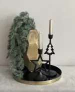 Kerstdecoratie. Gouden vaas met kersttak en kerst kandelaren.