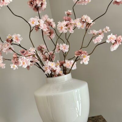 Beige vaas met roze zijden bloesemtakken