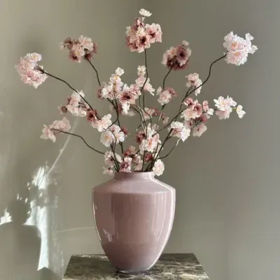 Roze vaas met zijden bloesemtakken