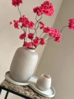 Beige vaas met fuchia bloesems