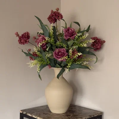 Beige vaas met zijden bloem boeket aubergine