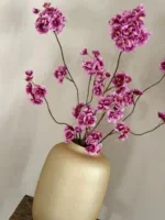 Gouden vaas met zijden bloesem takken lila paars fuschia