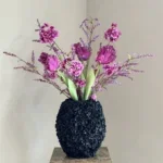 Zwarte vaas met zijden bloem boeket paars fuschia