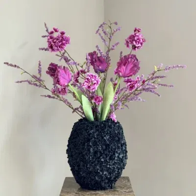Zwarte vaas met zijden bloem boeket paars fuschia