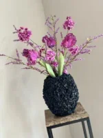 Zwarte vaas opgemaakt met zijden bloemen