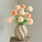 Beige vaas met pom pom takken